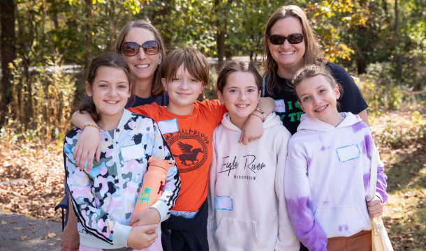 two girl scout troop leaders standing behind group of four girl scouts outside