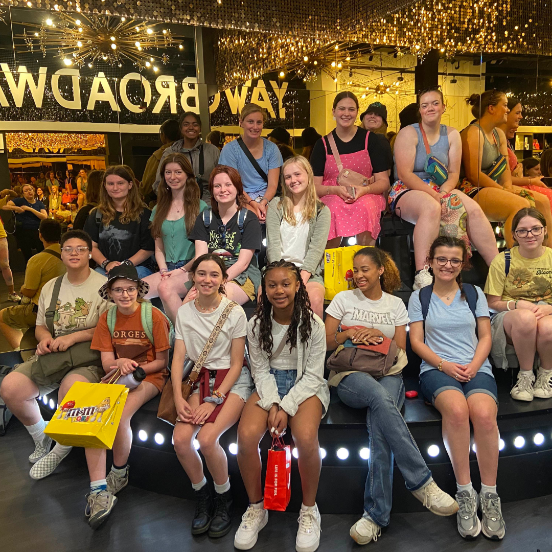 group of girl scouts posing with broadway sign