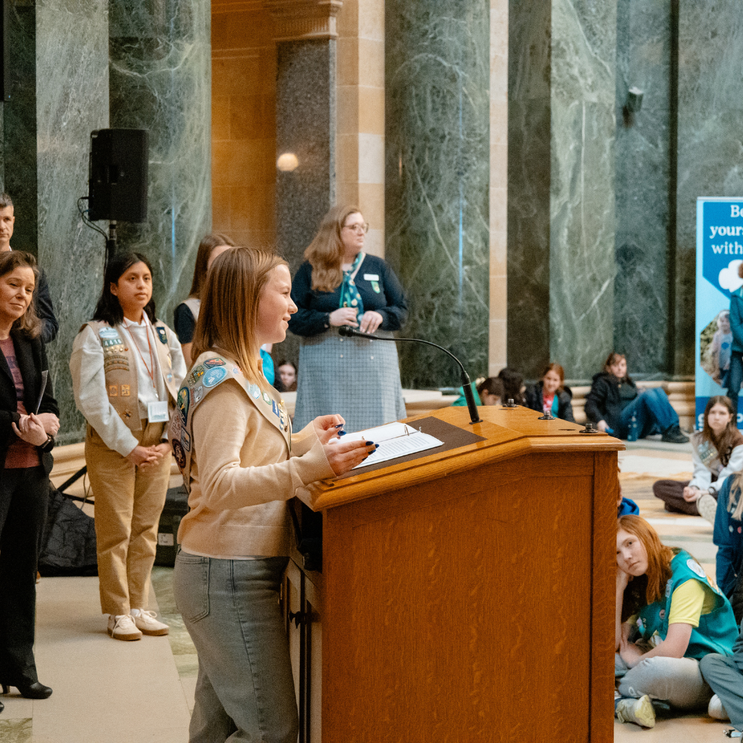 girl scout speaking at podium to other girl scouts in wisconsin state capitol