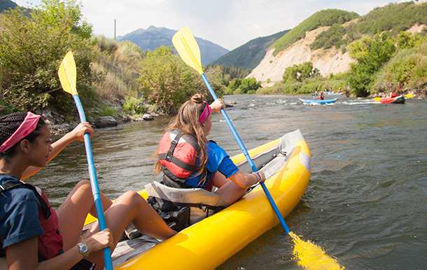 girl scouts kayaking in river