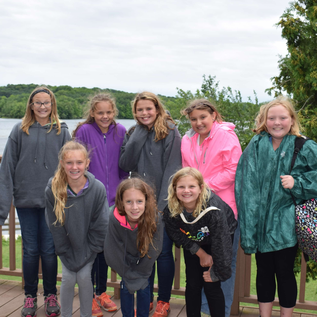 girl scouts in jackets in front of water