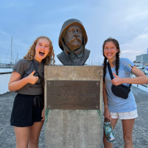 two girl scouts posing with statue