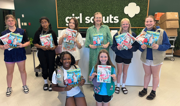 girl scouts holding up magazines