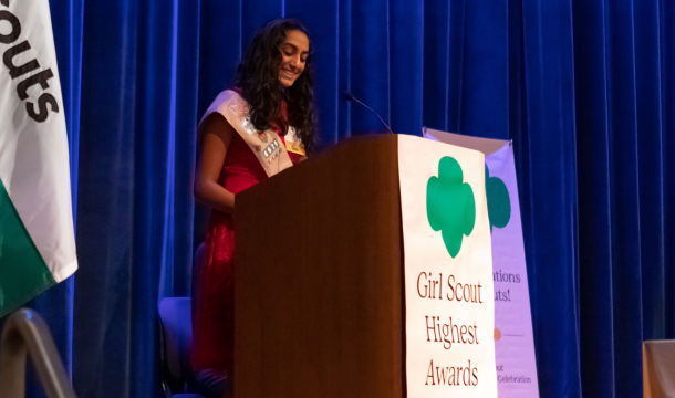 gold award girl scout speaking at podium