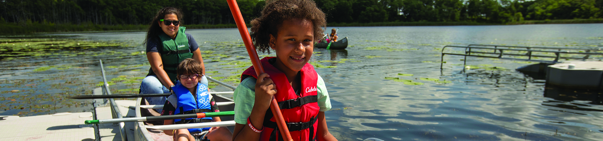  young Girl Scouts canoeing at summer camp 