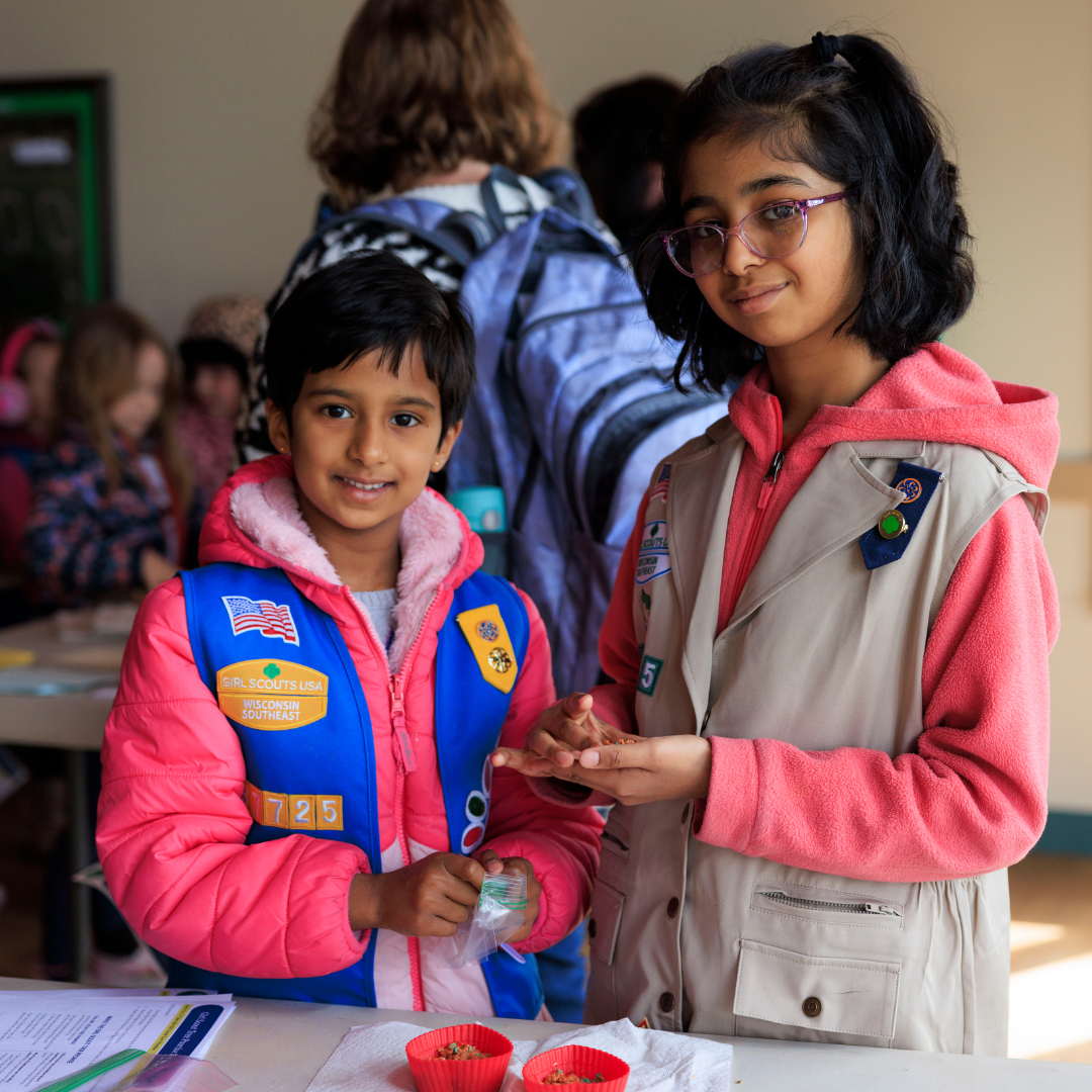 two girl scouts smiling at camera working on stem project