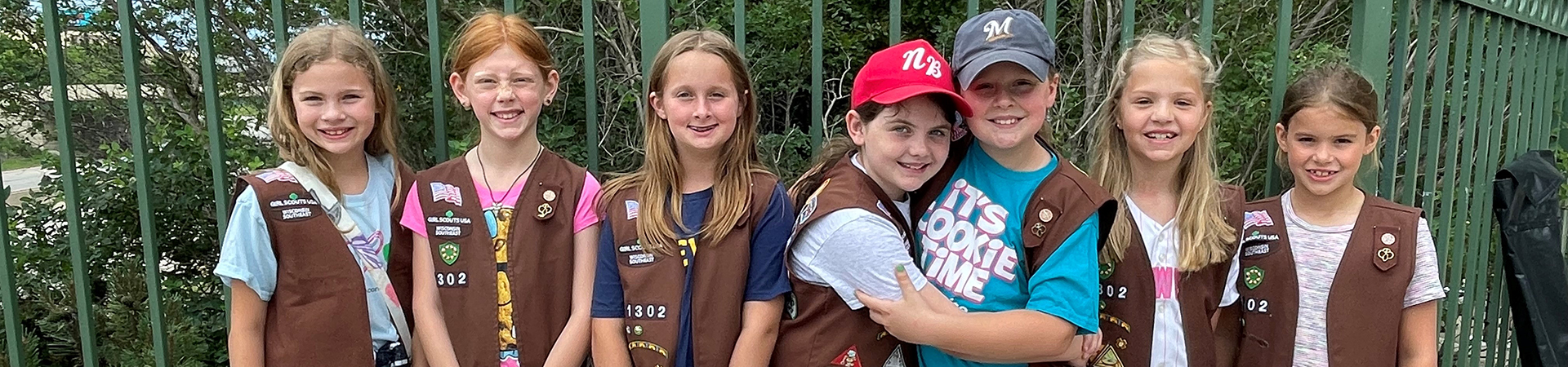  group of Girl Scout brownies smiling and hugging 