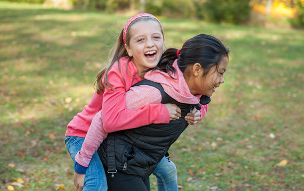 Girl Scout providing a piggyback 