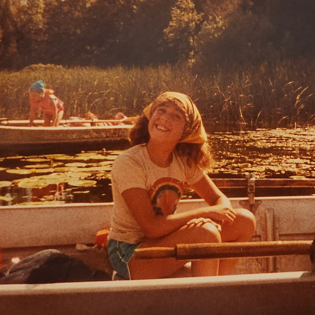 girl scout sitting on canoe