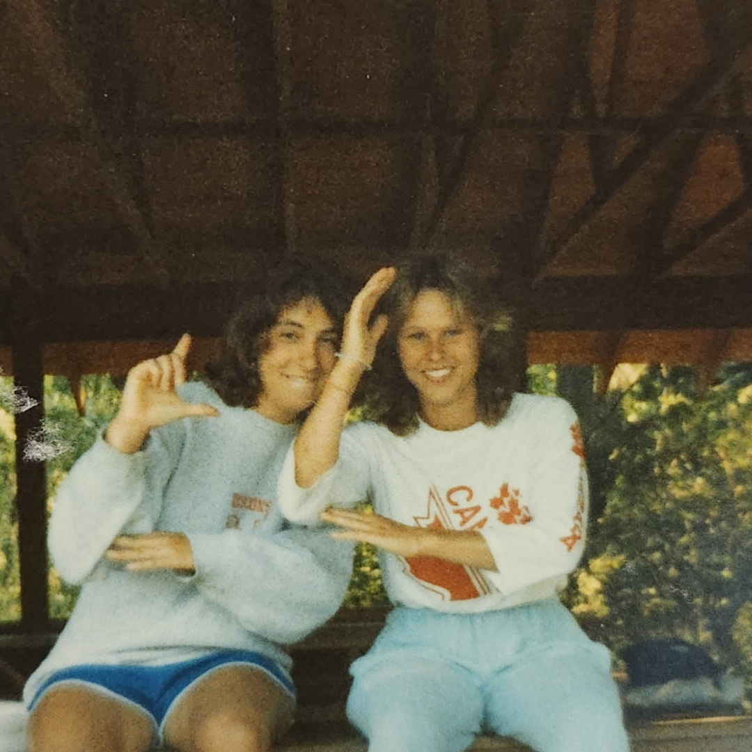 two girl scouts on top of table motioning with arms