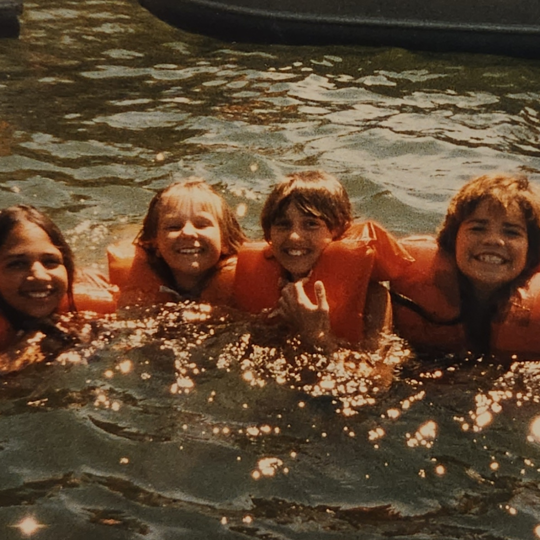 four girl scouts in water with life jackets
