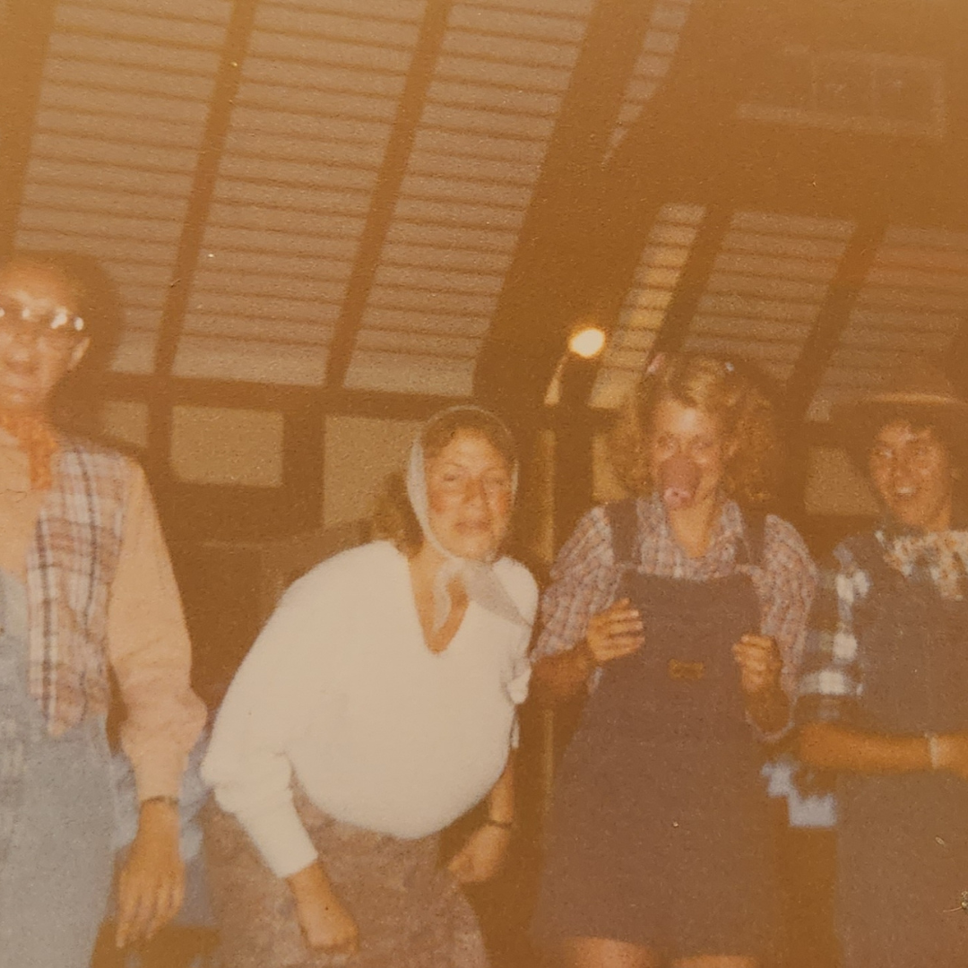 four girl scouts acting out skit in costumes in lodge