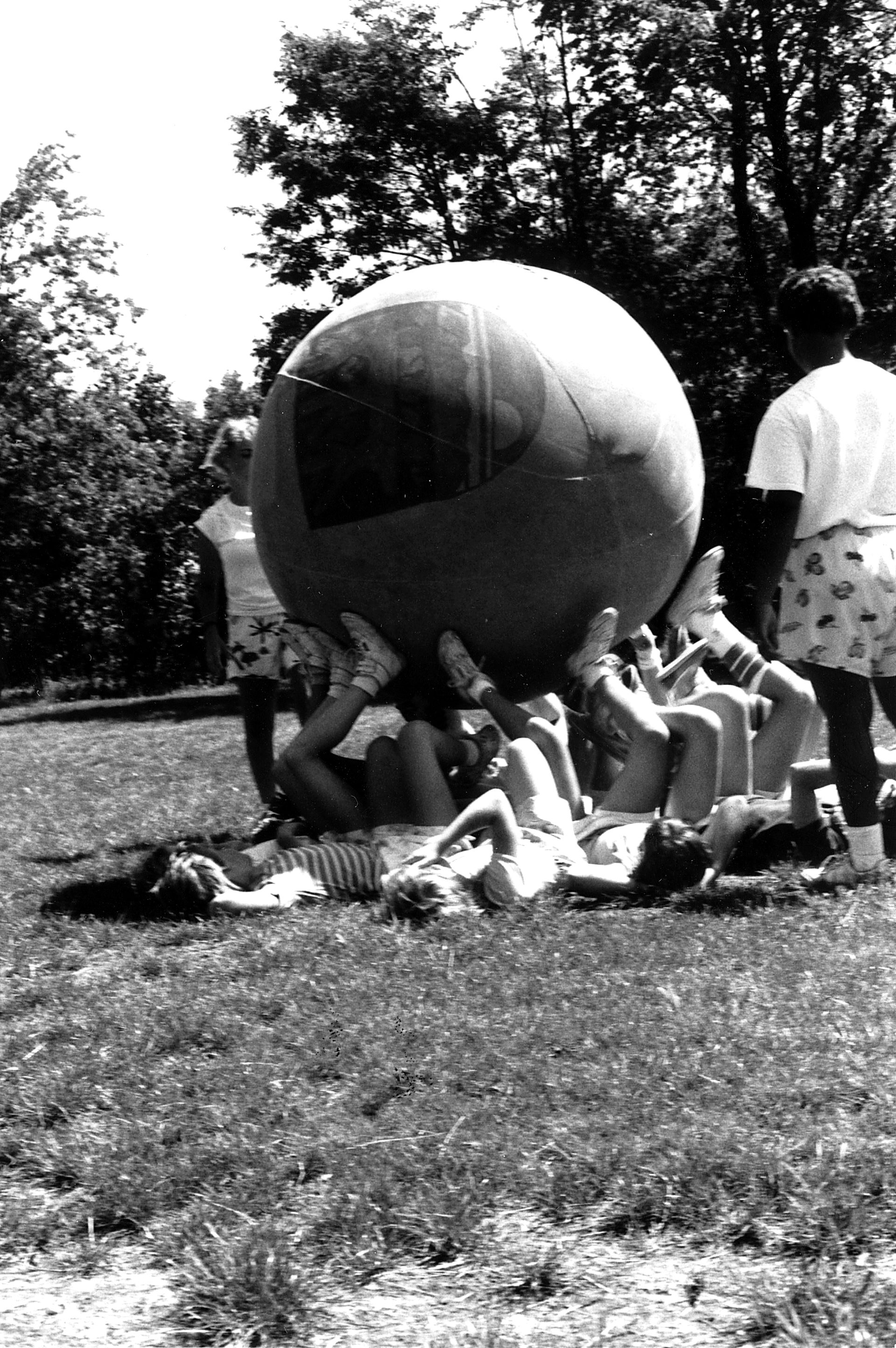 vintage black and white photo of girl scouts with big ball on sports field