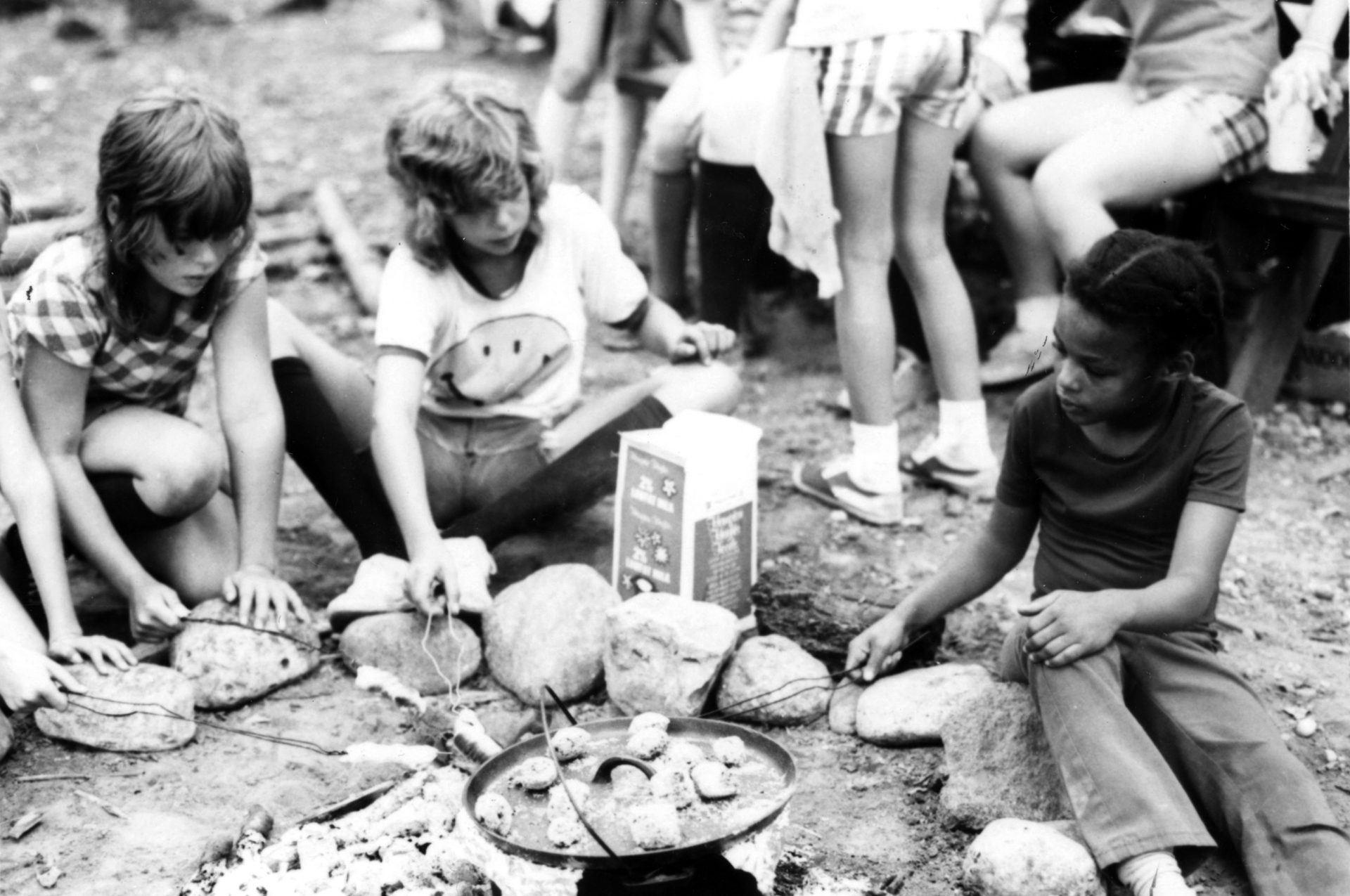 vintage black and white photo of campers around fire
