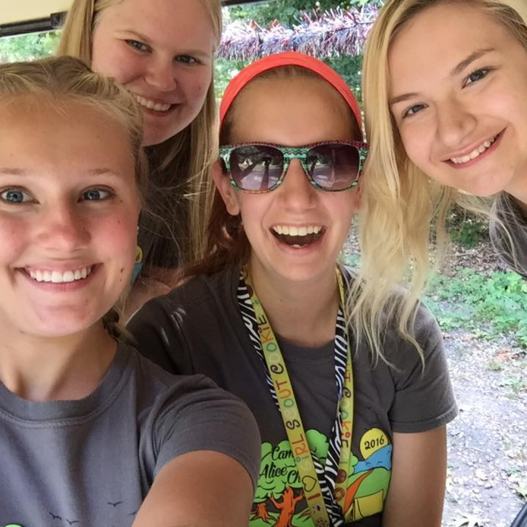 four girl scouts smiling at camera with selfie