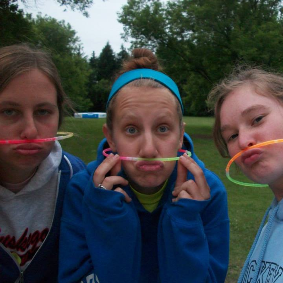three girl scouts posing with glow stick mustaches