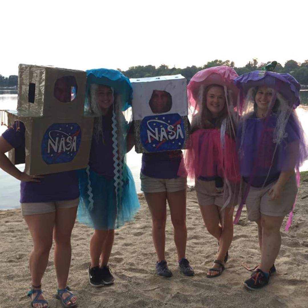 girl scouts dressed up as jellyfish and nasa in front of lake
