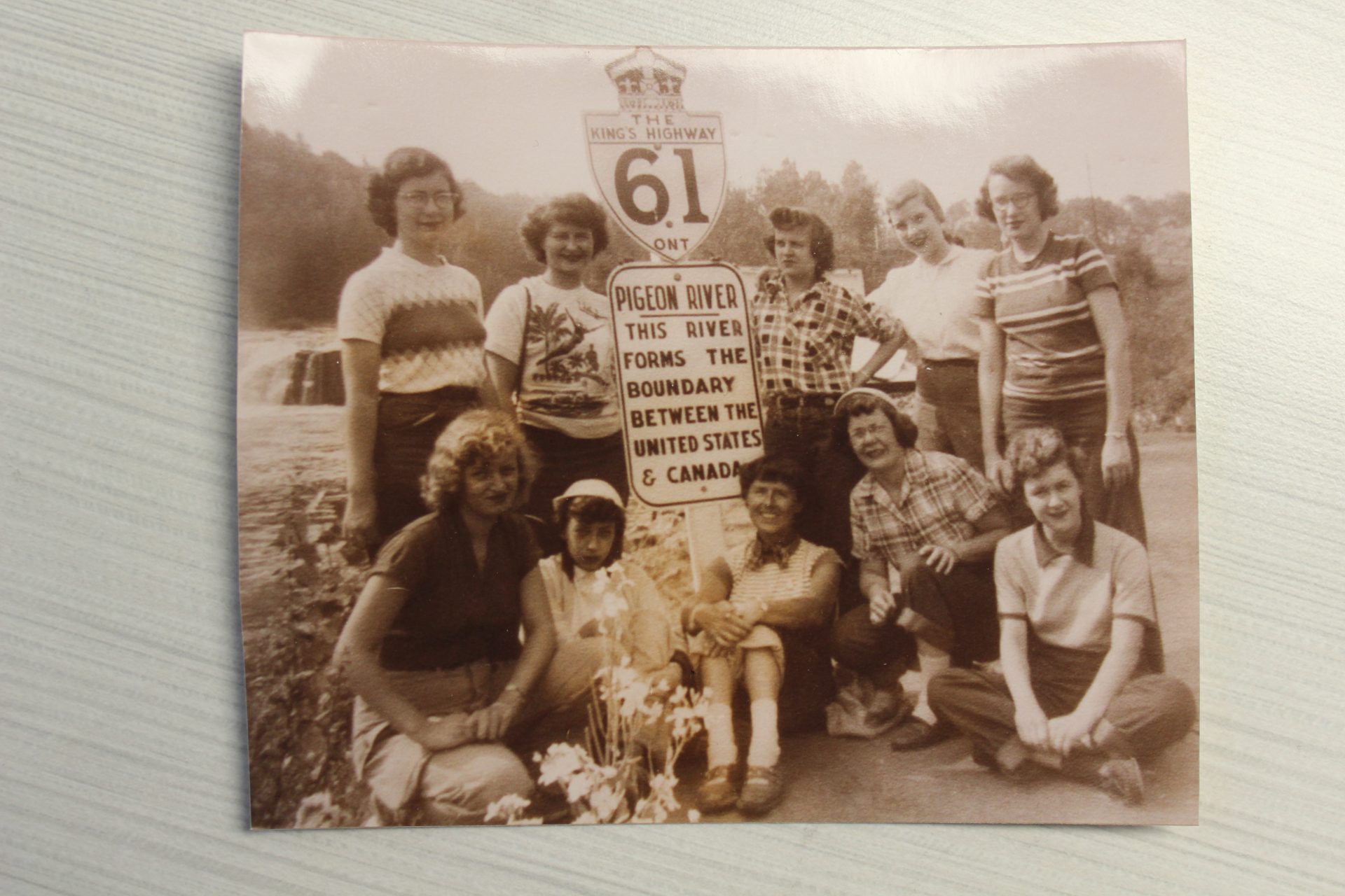 historic vintage sepia photo of girl scouts in front of road sign