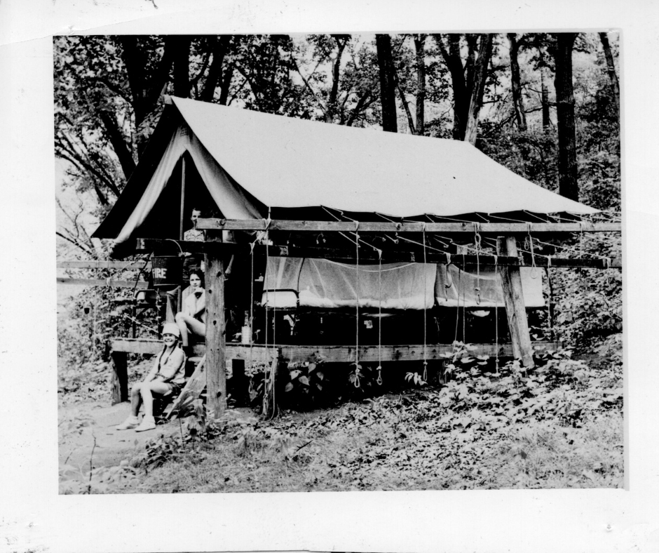 historic vintage black and white photo of girl scout outside tent
