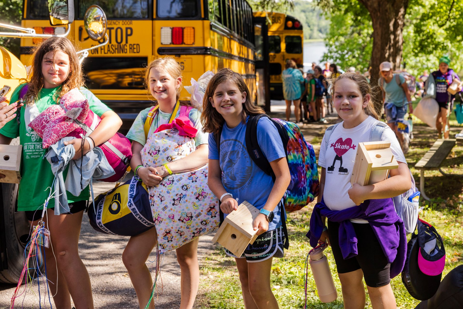 girl scouts outside of bus at summer camp