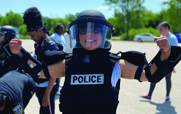three girl scouts walking on hiking path in wooded area 