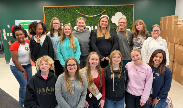 group of older girl scouts posing in office lobby