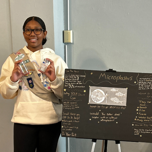 girl scout showing off posterboard presentation