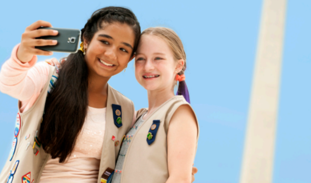 girl scouts taking selfie in front of monument