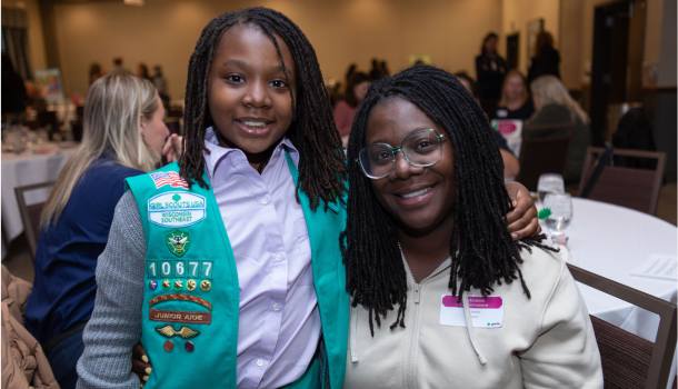 girl scout junior hugging mom at awards ceremony