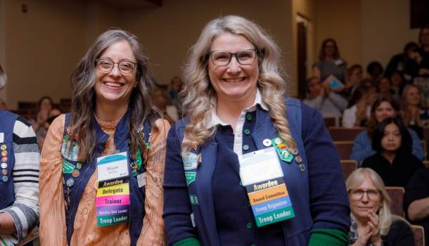 two girl scout volunteers smiling at camera at awards ceremony