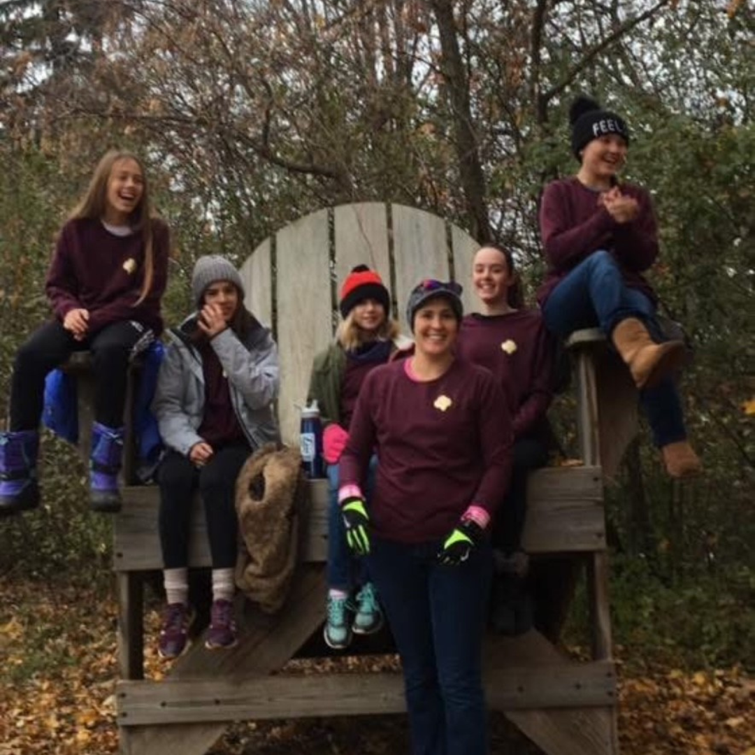 girl scout troop on oversized chair outside
