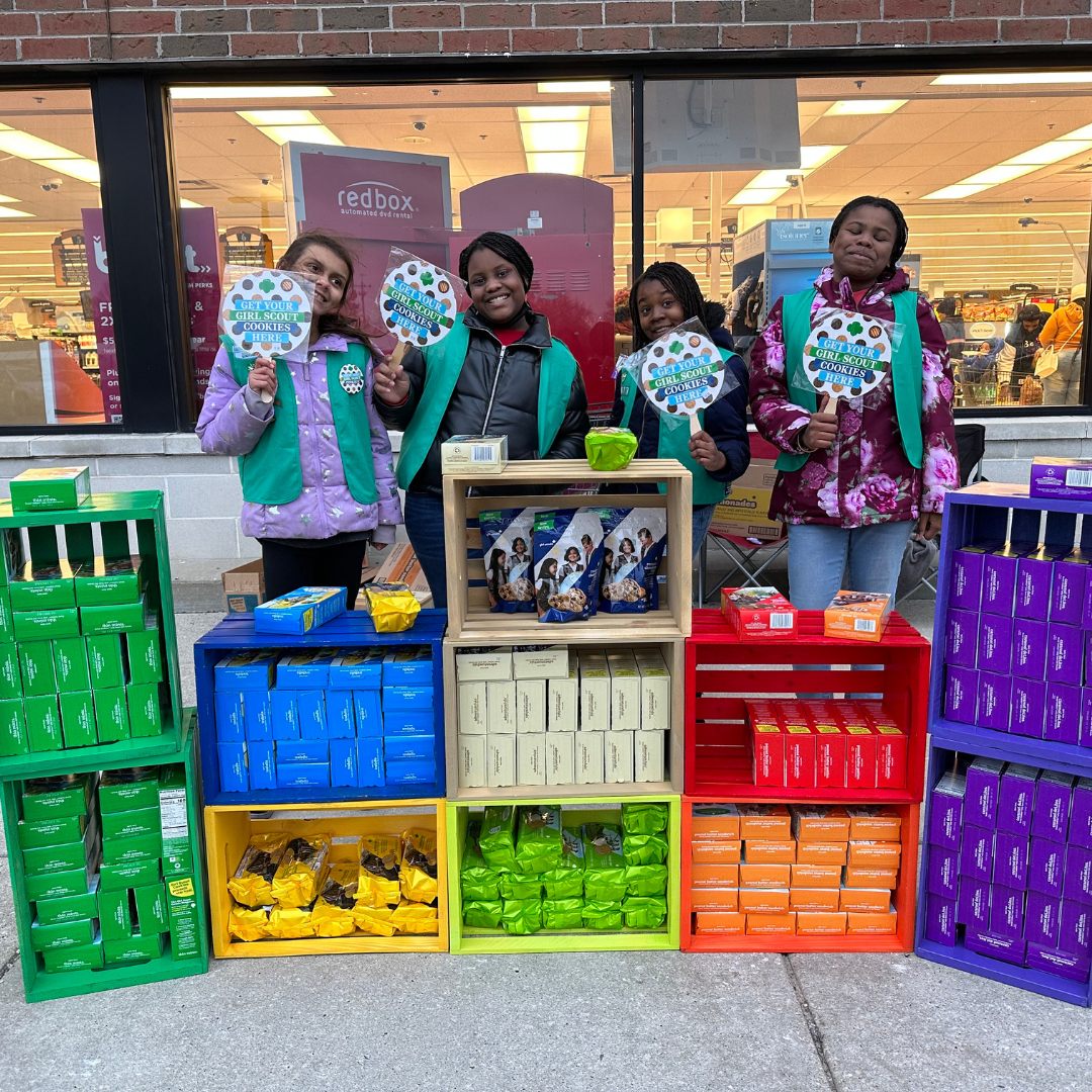 four girl scout juniors posing at cookie booth