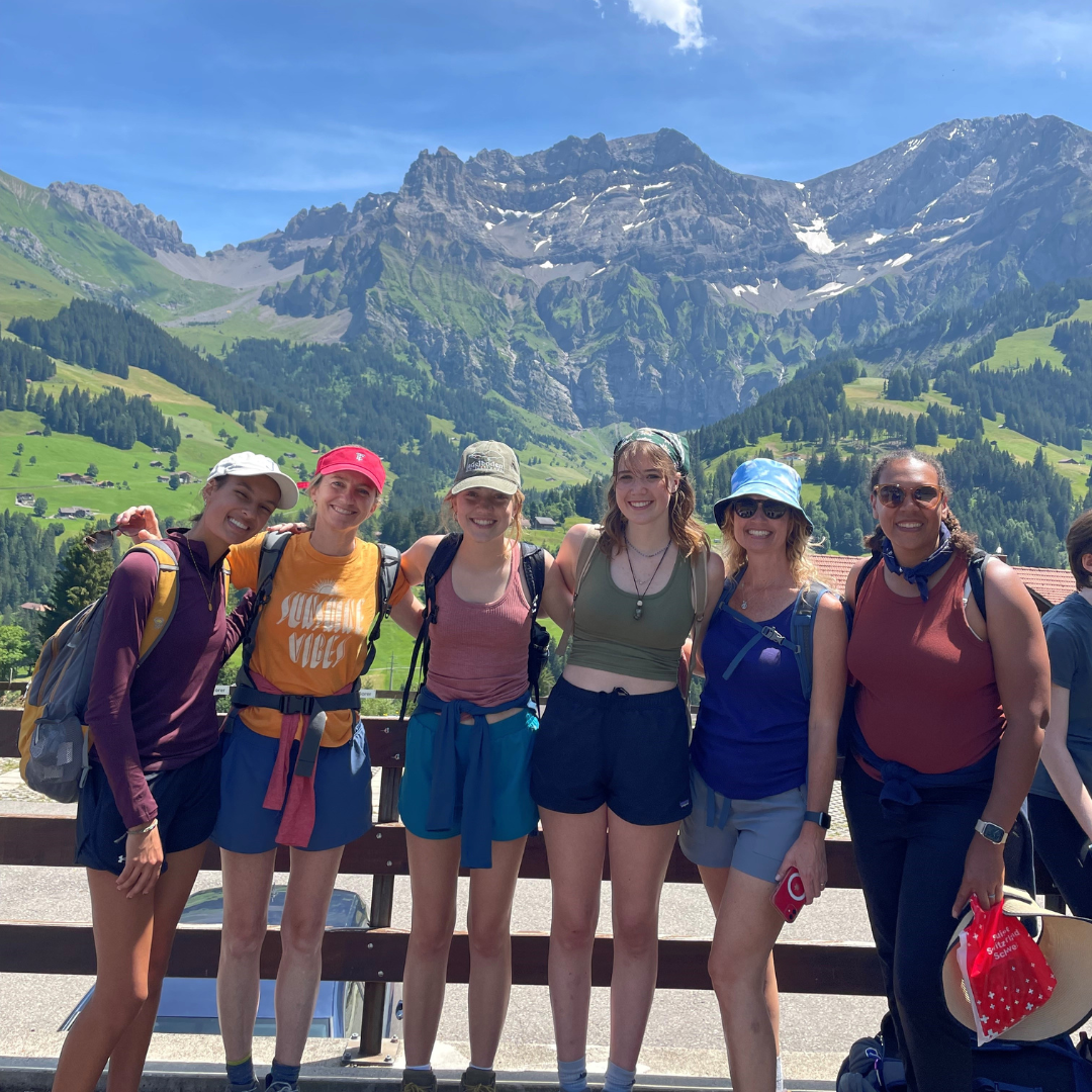 girl scout troop and troop leader posing in switzerland with alps