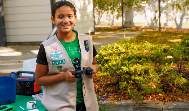girl scout outdoors with gaming console