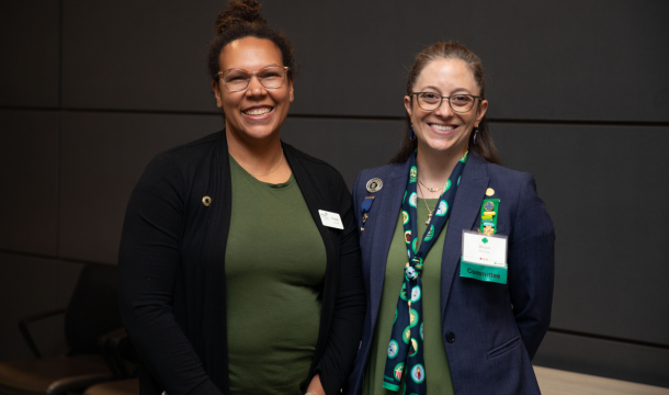 two girl scout volunteers dressed up smiling at the camera