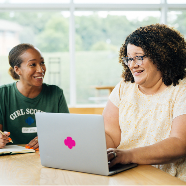 two girl scout volunteers looking at computer