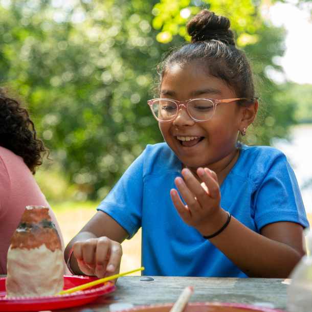 girl scout working on arts and crafts at summer camp