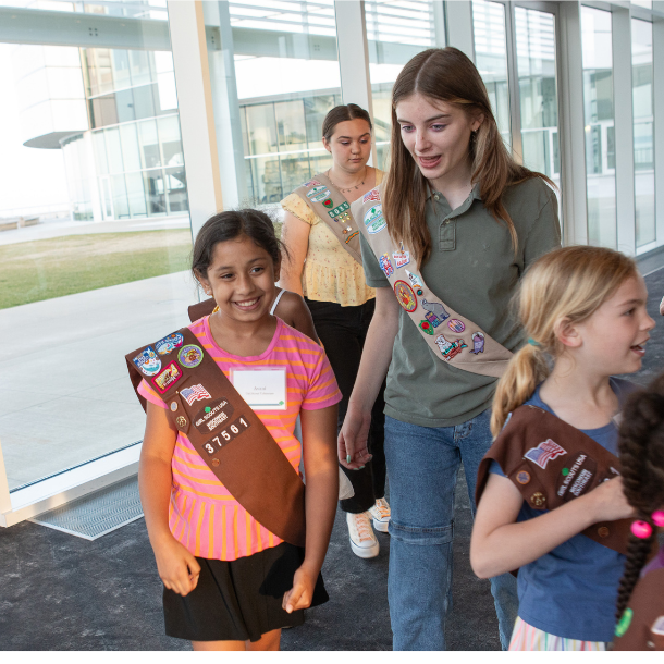 brownie and cadette girl scouts smiling at event